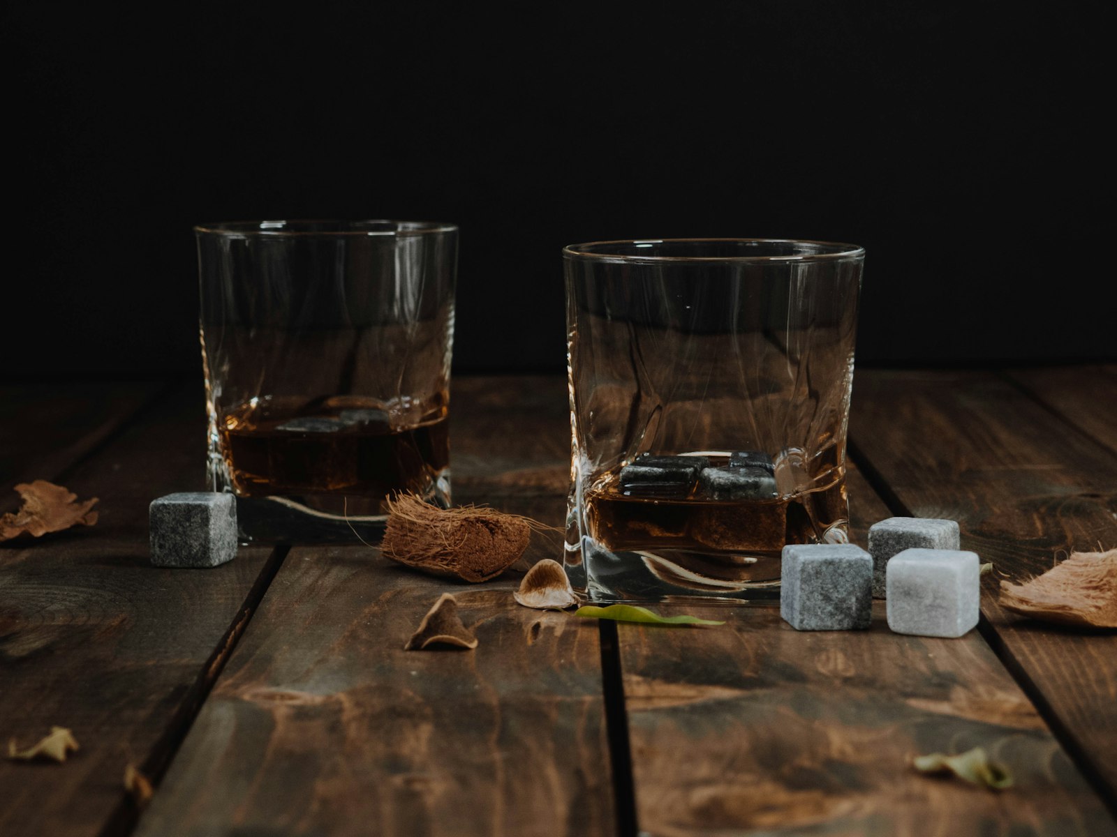 Két whiskys pohár egy fa asztalon, jégkockákkal
